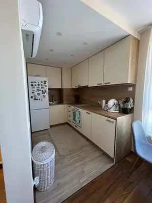a kitchen with white cabinets and a white refrigerator at Cozy and bright apartment in Sofia