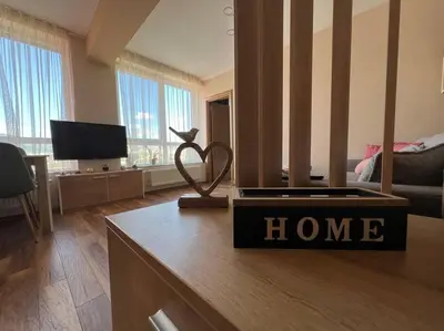 a living room with a home sign on a table at Cozy and bright apartment in Sofia