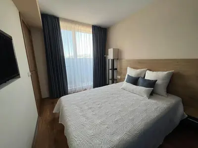 a bedroom with a large bed and a large window at Cozy and bright apartment in Sofia
