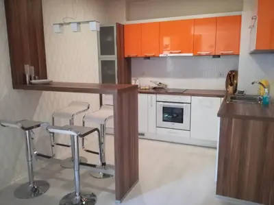 a kitchen with orange cabinets and a counter and stools at Top luxury apartment, great location in Sofia