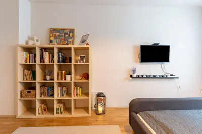 a room with a book shelf with books and a tv at Our Place in Sofia
