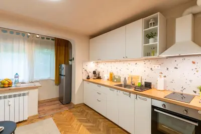 a kitchen with white cabinets and a refrigerator at Our Place in Sofia