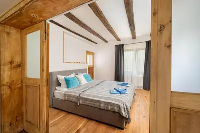 a bedroom with a bed with blue pillows at Къща за гости Остриля in Cherni Vit