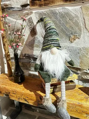 a gnome sitting on a table next to a vase at STENATA Sport Apartments in Pamporovo