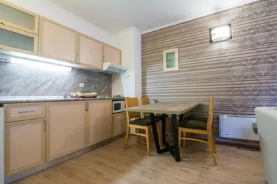 a kitchen with a table and a table and chairs at STENATA Sport Apartments in Pamporovo