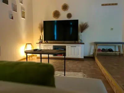 a living room with a flat screen tv on a table at Вила Форте Villa Forte in Pamporovo