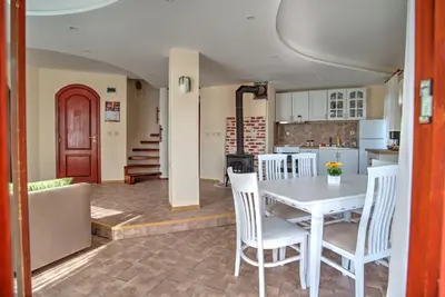 a kitchen and dining room with a table and chairs at Вила Форте Villa Forte in Pamporovo