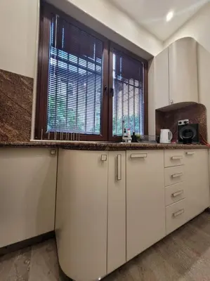 a kitchen with white cabinets and two windows at Luxury apartment Sofia top centre in Sofia