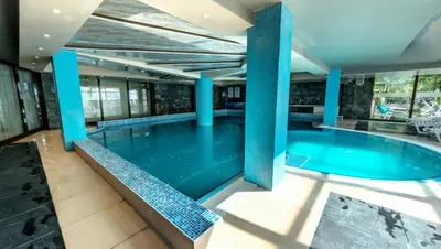 a swimming pool with blue columns in a building at Belvedere Holiday Club H41 in Bansko