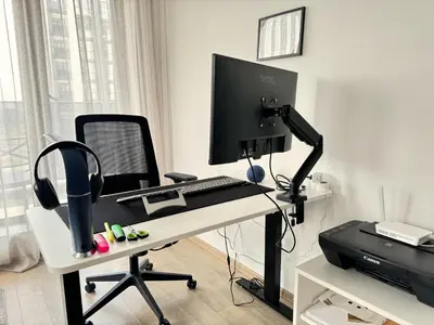 a desk with a computer monitor and a keyboard at Urban Exec Suite with Free Gym Pass, Full Office Setup and Designated Parking Space in Plovdiv