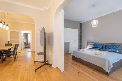 a bedroom with a bed and a table and a television at Gorgeous 2 BDRM fully equipped flat, TOP location in Sofia