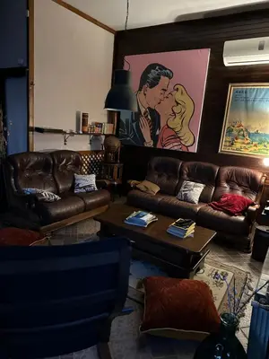 a living room with couches and a painting of a kissing couple at Villa Le Cinema in Shiroki Dol