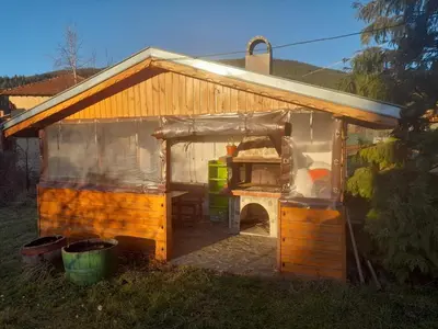 a small building with a stove in a yard at Къща за гости Дани in Govedartsi