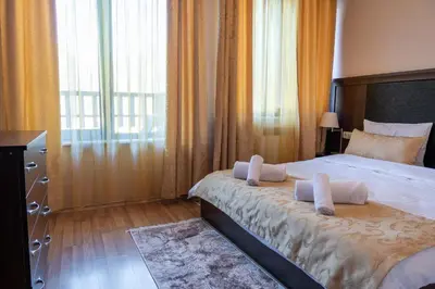 a bedroom with a bed and a large window at Апартамент и Студия 