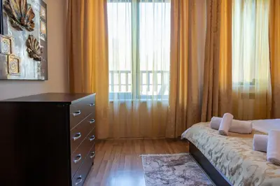 a bedroom with a bed and a dresser and a window at Апартамент и Студия 