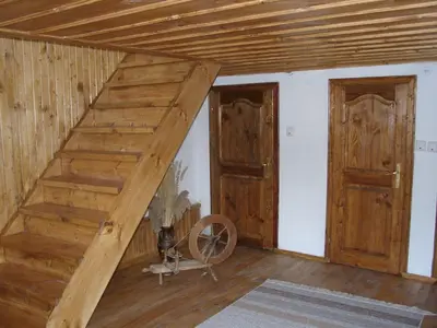 an attic room with wooden stairs and two doors at Sarafova Guest House in Koprivshtitsa