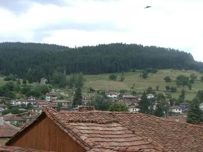 a view of a town with a mountain in the background at Sarafova Guest House in Koprivshtitsa
