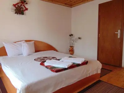 a bedroom with a bed with white sheets at Sarafova Guest House in Koprivshtitsa