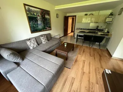 a living room with a couch and a kitchen at The Nature View Suite, part of Terra Complex & Spa in Bansko