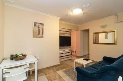 a living room with a blue couch and a tv at Charming Artistic Central Apartment in Sofia