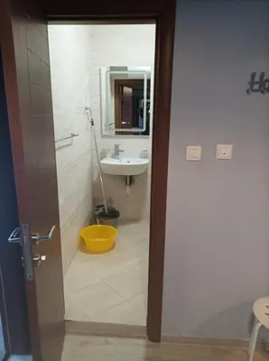 a bathroom with a sink and a mirror and a door at One Bedroom Apartment 61 - Restaurant Stadium Plovdiv in Plovdiv