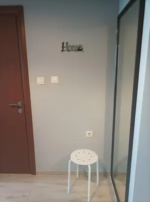 a white stool in a room with a sign on the wall at One Bedroom Apartment 61 - Restaurant Stadium Plovdiv in Plovdiv