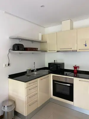 a kitchen with white cabinets and a black counter top at M&R Apartment C13 - SPA Terra Complex in Razlog