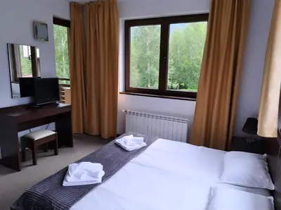 a bedroom with a bed and a desk and a window at M&R Apartment C13 - SPA Terra Complex in Razlog