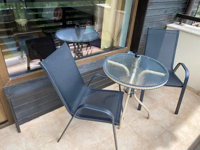 a glass table and chairs sitting on a patio at M&R Apartment C13 - SPA Terra Complex in Razlog