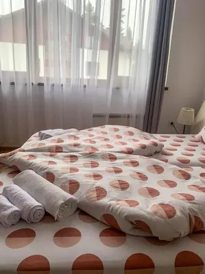 a bed with red and white sheets and towels on it at Cozy Rila Park Apartments in Borovets