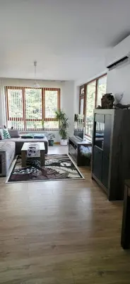 a living room with a couch and a table at Cozy Rila Park Apartments in Borovets