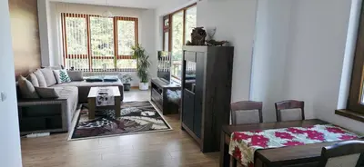 a living room with a couch and a table at Cozy Rila Park Apartments in Borovets