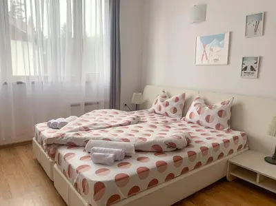 a bedroom with a large bed with towels on it at Cozy Rila Park Apartments in Borovets