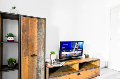 a tv sitting on top of a wooden cabinet at Budget Stay Near Sofias Lions Bridge in Sofia