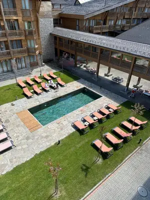 an overhead view of a pool with lounge chairs and a hotel at Pirin Golf Hotel&Spa Apartment 42 - private luxury apartment in Razlog