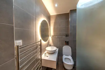 a bathroom with a toilet and a sink and a mirror at Pirin Golf Hotel&Spa Apartment 42 - private luxury apartment in Razlog