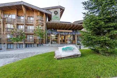 a building with a mattress in the grass in front of it at Pirin Golf Hotel&Spa Apartment 42 - private luxury apartment in Razlog