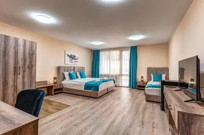 a hotel room with two beds and a flat screen tv at VALEMO Apart House in Devin