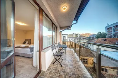 a balcony with a view of a bedroom and a bed at VALEMO Apart House in Devin