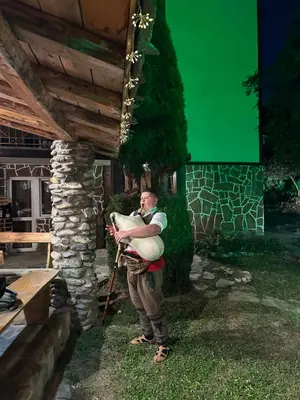 a man holding a baby in his sling at КЪЩА ЗА ГОСТИ ВОДЕНИЦАТА in Devin