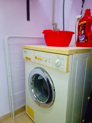 a washing machine with a red bowl on top of it at 