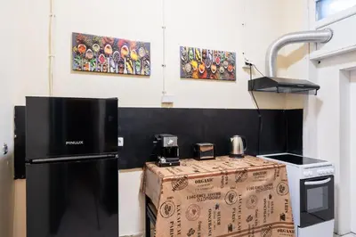 a kitchen with a refrigerator and a table in a room at The Green Bar House in Sofia