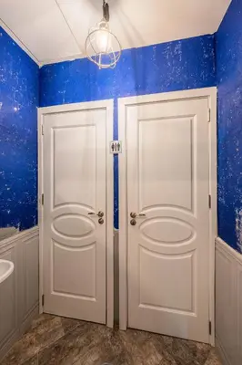 a bathroom with blue walls and white doors at The Green Bar House in Sofia