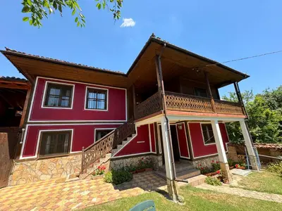 a large red house with a large balcony at Borimechkova Kashta in Koprivshtitsa