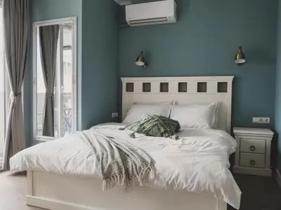 a bedroom with a white bed with a blue wall at Stylish 1BD - Free Private Garage in Plovdiv