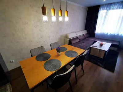 a dining room with a table and a couch at Viva 3 Grand monastery in Pamporovo