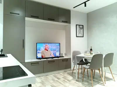 a kitchen with a tv and a table with chairs at Bijoux Apt in the heart of Sofia in Sofia