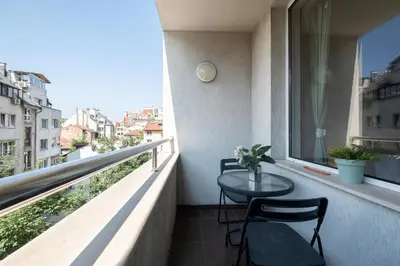a balcony with two chairs and a table on a balcony at City Oasis: Stylish Retreat in the Heart of Sofia in Sofia