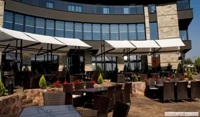 a restaurant with tables and chairs and a building at Face Hotel in Sofia