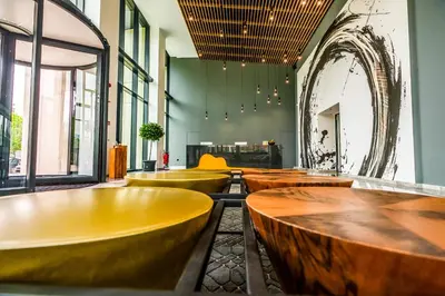 a row of wooden tables in a room with windows at B1 City Hotel Sofia in Sofia